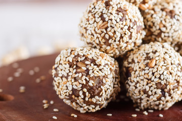 Energy balls cakes with almonds, sesame, cashew, walnuts, dates and germinated wheat, side view, close up.