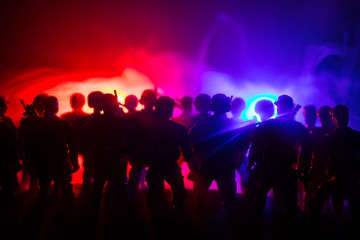 Anti-riot police give signal to be ready. Government power concept. Police in action. Smoke on a dark background with lights. Blue red flashing sirens.