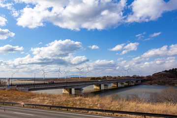 風力発電と道路を走行する自動車　自然エネルギー　イメージ