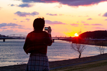きれいな夕焼けを撮影している女性