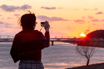 きれいな夕焼けを撮影している女性