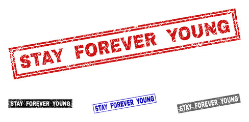 Grunge STAY FOREVER YOUNG rectangle stamp seals isolated on a white background. Rectangular seals with distress texture in red, blue, black and gray colors.