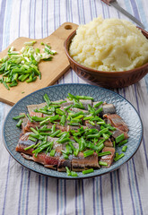 Herring fillet with green onions with mashed potatoes.