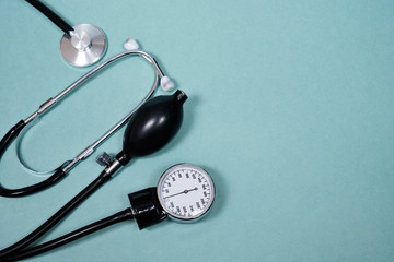 phonendoscope and tonometer  with pills   on a blue background. Copy space