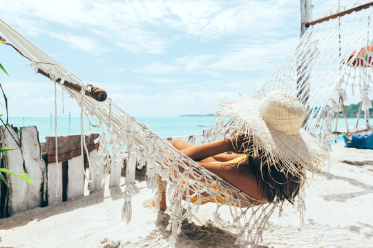 Girl relaxing in hammock in tropical beach cafe