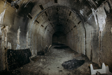 Fototapeta na wymiar Long underground tunnel or corridor in abandoned Soviet military bunker or basement with creepy atmosphere