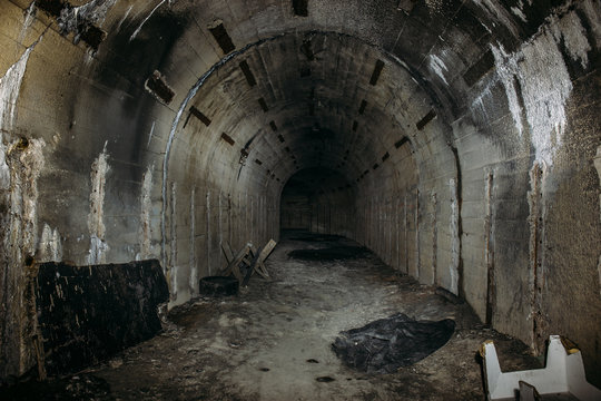 Fototapeta Long underground tunnel or corridor in abandoned Soviet military bunker or basement with creepy atmosphere
