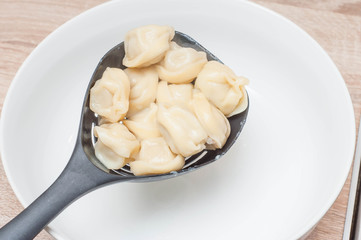 Sieve with dumplings on the background of a white plate ready to serve