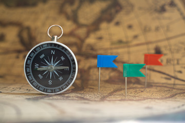 Compass on old vintage brown map background, journey planning concept