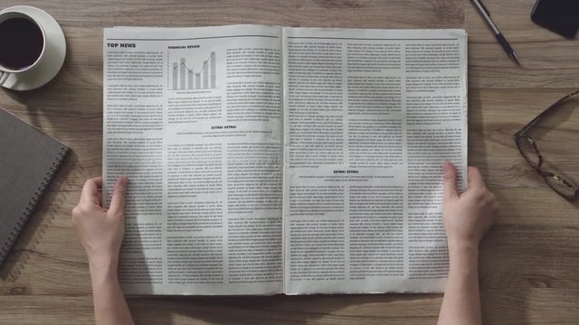 Hands open the the business Newspaper on wooden table in the office, Daily Newspaper mock-up concept