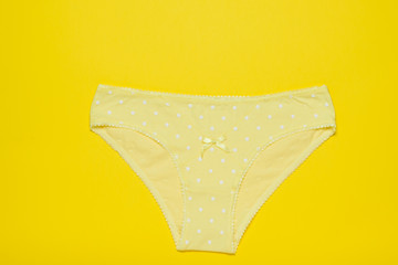 Yellow women's cotton panties on a bright yellow background. Fashionable concept. Beautiful...