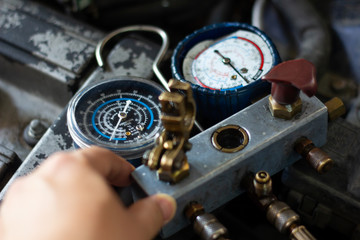 Auto mechanic worker fixing air condition in car garage. Monitoring tools check car air conditioner...