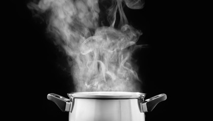 steam over cooking pot in kitchen on dark background