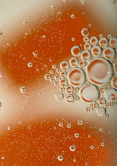 Abstract blurred background. White and orange circles and bubbles of different sizes. Cropped shot, macro, vertical, nobody, gradient, free space for text.