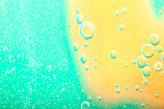 Abstract blurred background. Delicate turquoise and yellow circles and bubbles of different sizes. Cropped shot, macro, horizontal, nobody, gradient, free space for text.