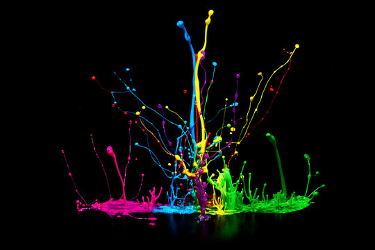 Colorful abstract paint splashing on audio speaker isolated on black background