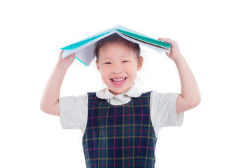 Little asian girl in uniform holding book and smiling over white background