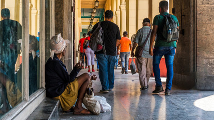 Havana, Cuba. Ignorant people passing by a woman who`s begging on the streets of the city.