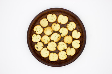Bake Rolls. The mini bread chips on the brown bowl. Isolated on white background.