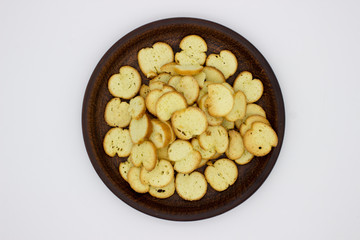 Bake Rolls. The mini bread chips on the brown bowl. Isolated on white background.