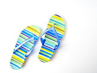 Colorful striped flip flops on white background