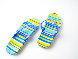 Colorful striped flip flops on white background