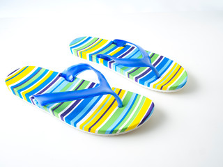 Colorful striped flip flops on white background