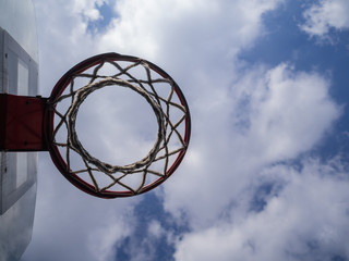 Basketball ring against the background of the blue sky with clouds. Sports ground