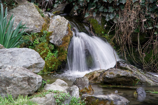 Flowing water stream, water drops and reflection