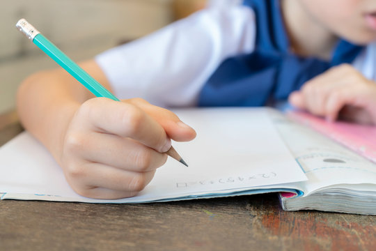 Students who are holding pencils for math calculation.