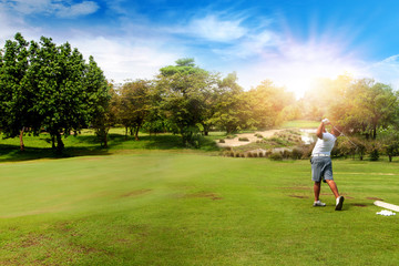 Panorama of Golfer hit sweeping golf ball on blurred beautiful golf course with sunshine on background.	
