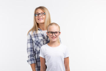 Portrait of mother and daughter with eyeglasses on white background