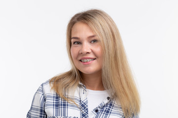 Teeth health, dentistry and bite correction - Happy smiling woman with braces on white background