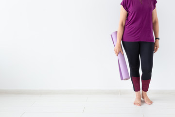 Yoga, peopel concept - Close up of woman holding mat after a yoga class on white background with copy space