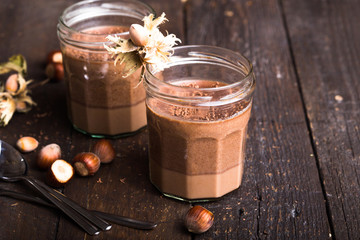 Chocolate pannacotta with nuts on black background.