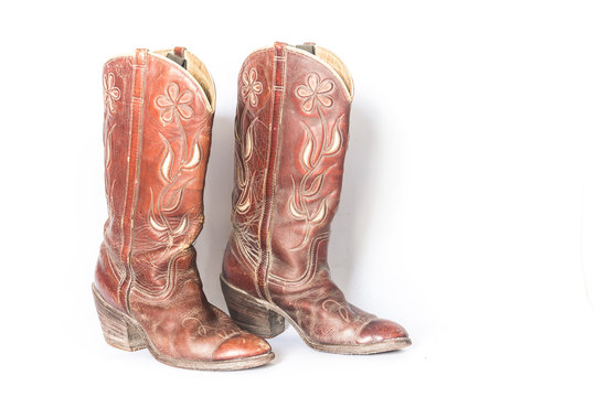 Old dirty cowboy boots on a white background