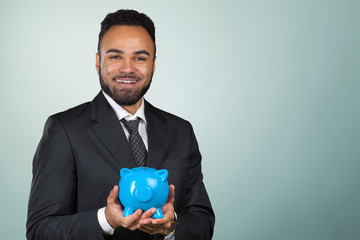 African American business man holding a piggy bank