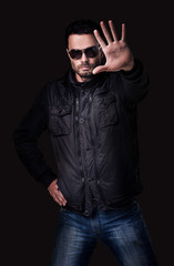 Fototapeta premium Handsome young man in sunglasses shows stop gesture.