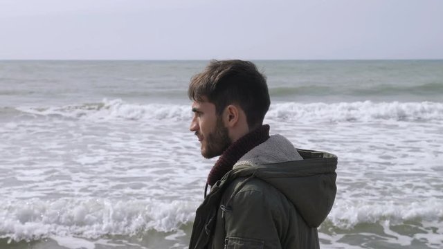 Depressed thoughtful young man walking alone on the beach.Thoughts,worries