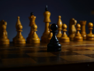 Brave ambitious businessman and challenge. Black wooden pawn and white chess.