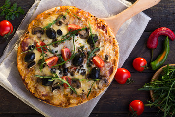 Pizza served with dill. Pizza with tomatoes black olives and ham.