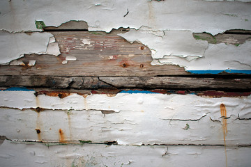 Close up of paint peeling off old wooden ship, background