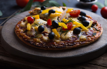 Pizza served with dill. Pizza with tomatoes black olives and ham.