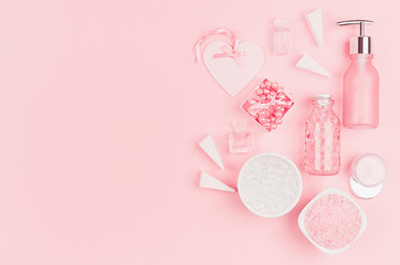Natural skin care products, accessories for bathroom - cream, salt, essential oil, soap, perfume, pearls, gift, box, bottles, heart, bowl on pink background.
