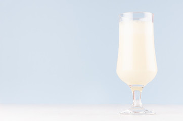 Fresh oranges milkshake in gentle graceful soft light blue interior, copy space.