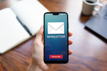 Newsletter subscription button on mobile phone screen. Business marketing concept.
