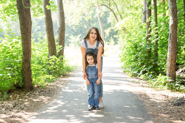 Family and nature concept - Young woman with little girl have fun outdoors