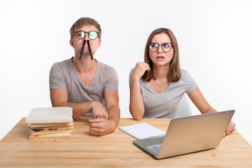 Education, fun and people concept - a couple of young people in glasses look like they are bored of...