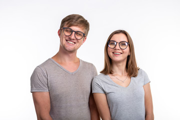 Education, people concept - a couple of young people in glasses look like they are nerds standing over the white background.