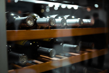 Storing bottles of wine in fridge. Alcoholic card in restaurant. Cooling and preserving wine.